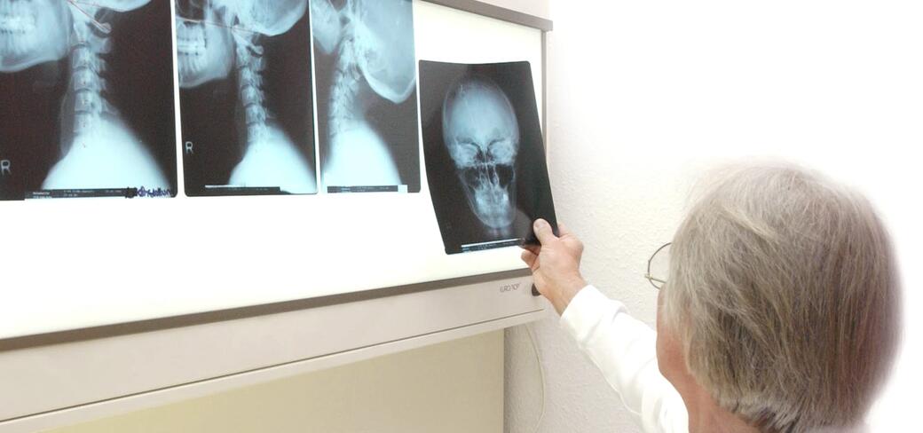 Dr. Strackharn analysiert Röntgenaufnahmen - Schmerz-Therapie-Zentrum Baden-Baden